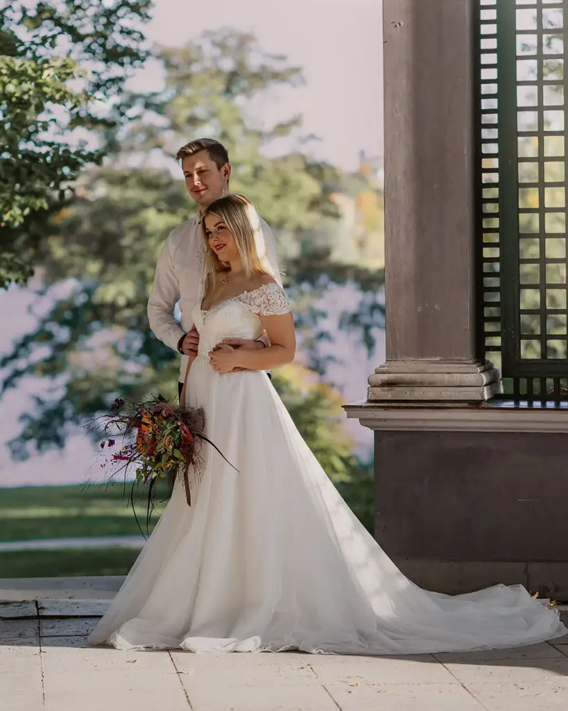 Brudpar stående vid pelare.