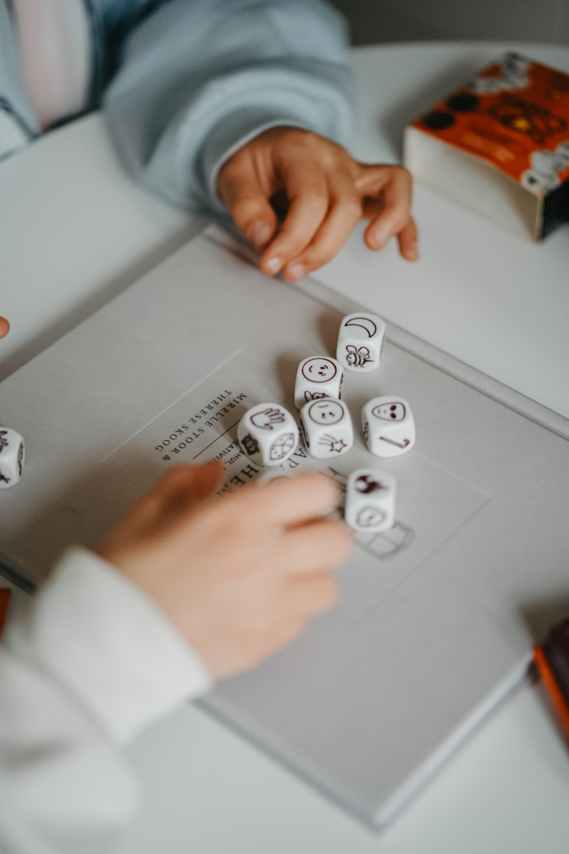 Små barns händer som spelar med tärningar – ett lekfullt och närvarande ögonblick