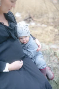 Gravid mamma med sonen lutandes mot magen